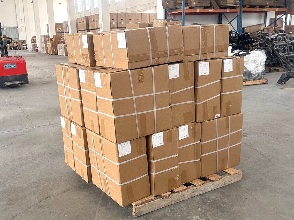 Cajas de repuestos apiladas sobre un pallet en el almacén.